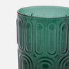 A close-up of a translucent teal green glass highball with a vertically ribbed, oval-patterned design, set against a plain light gray background.