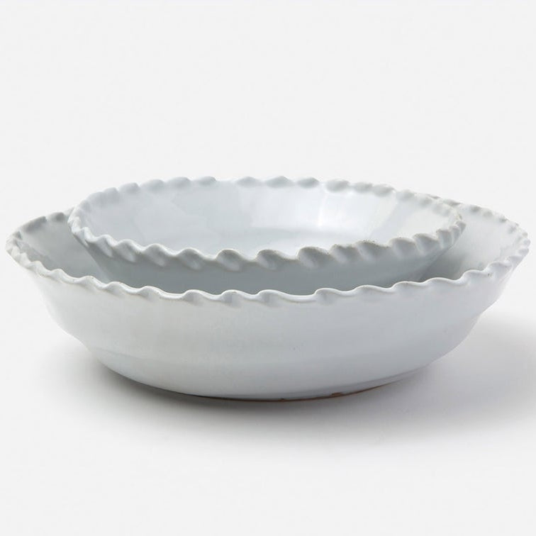 A pair of nested ceramic bowls with a scalloped, wavy rim, shown in a light gray color on a clean white background.