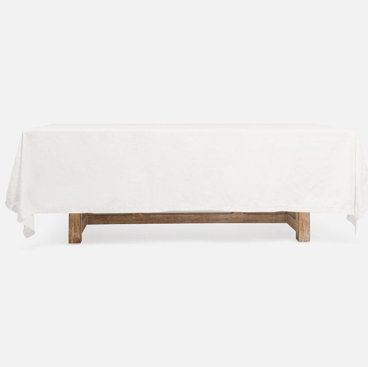 A rectangular table covered with a white tablecloth, supported by a rustic wooden base, shown against a plain white background.