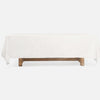 A rectangular table covered with a white tablecloth, supported by a rustic wooden base, shown against a plain white background.