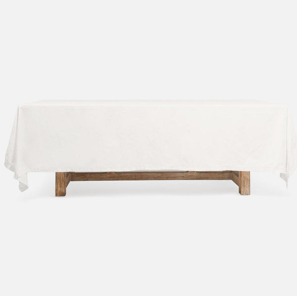 A rectangular table covered with a white tablecloth, supported by a rustic wooden base, shown against a plain white background.