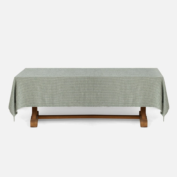 A rectangular table covered with a small-scale green and white gingham checkered tablecloth, shown against a plain light gray background.
