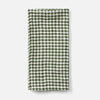 A folded green and white gingham checkered cloth napkin or tea towel, displayed vertically against a clean, light gray background.