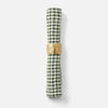 A rolled green and white gingham check napkin held in place by a textured gold paper ring, shown on a clean white background.