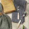 Checkered napkins and spoons on a marble surface