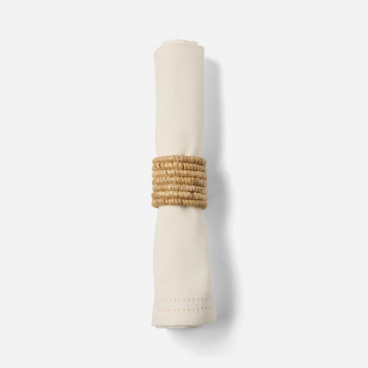 Beige napkin holder with woven design on a white background