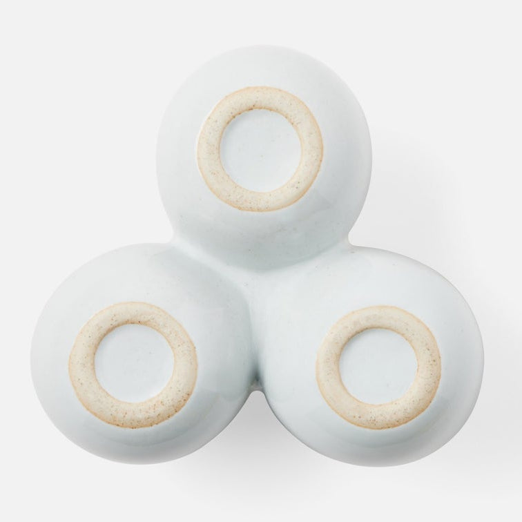Three small round stonware dishes with pale blue glaze and beige ring accents, arranged in a triangular cluster on a light gray background.
