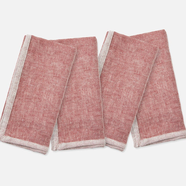 Two folded red and white patterned napkins on a light gray background