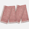 Two folded red and white patterned napkins on a light gray background