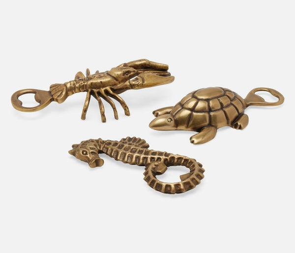 Three brass lobster, seahorse, and sea turtle-shaped bottle openers displayed on a light gray background.