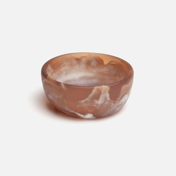 A small resin bowl, featuring natural brown and cream marbled patterns, set against a plain light gray background.