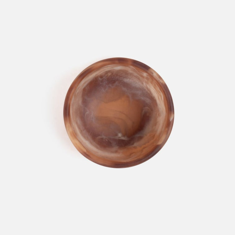 A round resin bowl with a swirling brown and amber pattern, photographed from directly above on a clean white background.