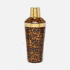 A classic cocktail shaker with a glossy tortoiseshell pattern in brown and amber, featuring polished gold metal caps and a gold accent band.