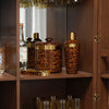 Leopard print barware set on a wooden shelf with a glass cabinet in the background.