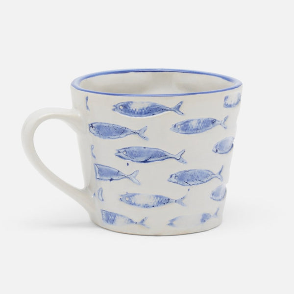 A white stoneware mug with a blue hand-painted fish pattern and a blue rim, shown on a clean white background.