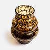 A small decorative glass vase with a rounded, tiered shape and a glossy amber-brown and black tortoiseshell pattern, photographed on a clean white background.