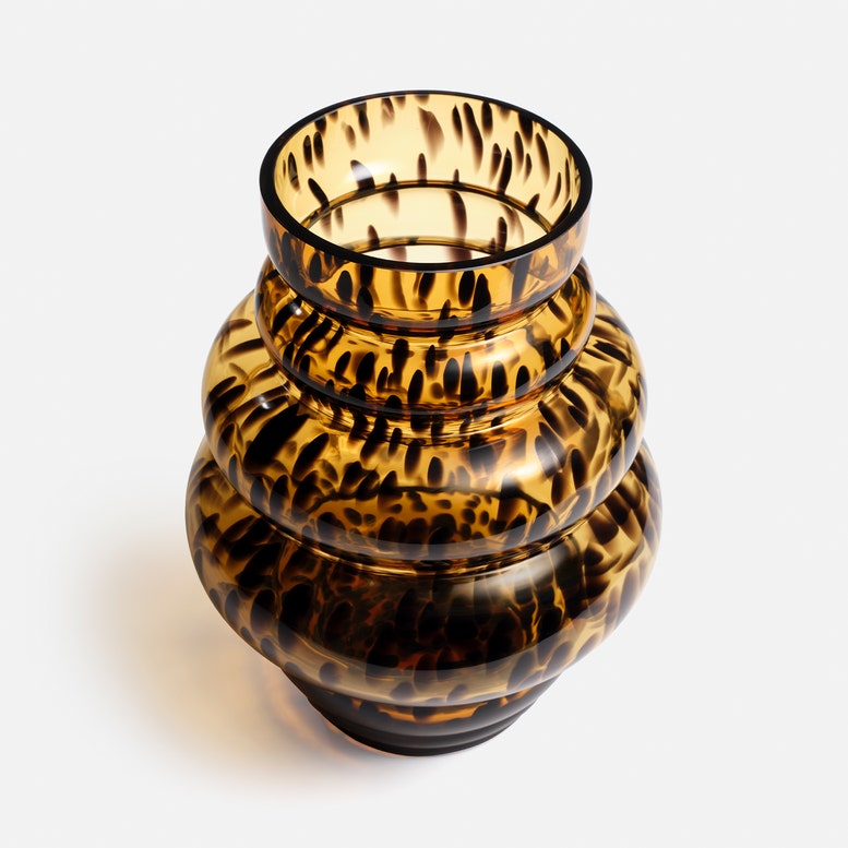 A small decorative glass vase with a rounded, tiered shape and a glossy amber-brown and black tortoiseshell pattern, photographed on a clean white background.