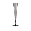 A tall, slender champagne flute made of smoky translucent glass with a flared rim and a dark, bulbous stem, centered on a plain white background.