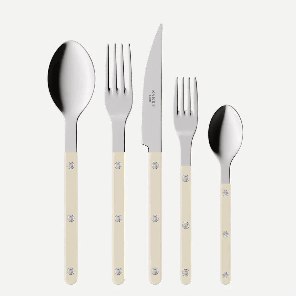Set of silver cutlery with beige handles on a white background
