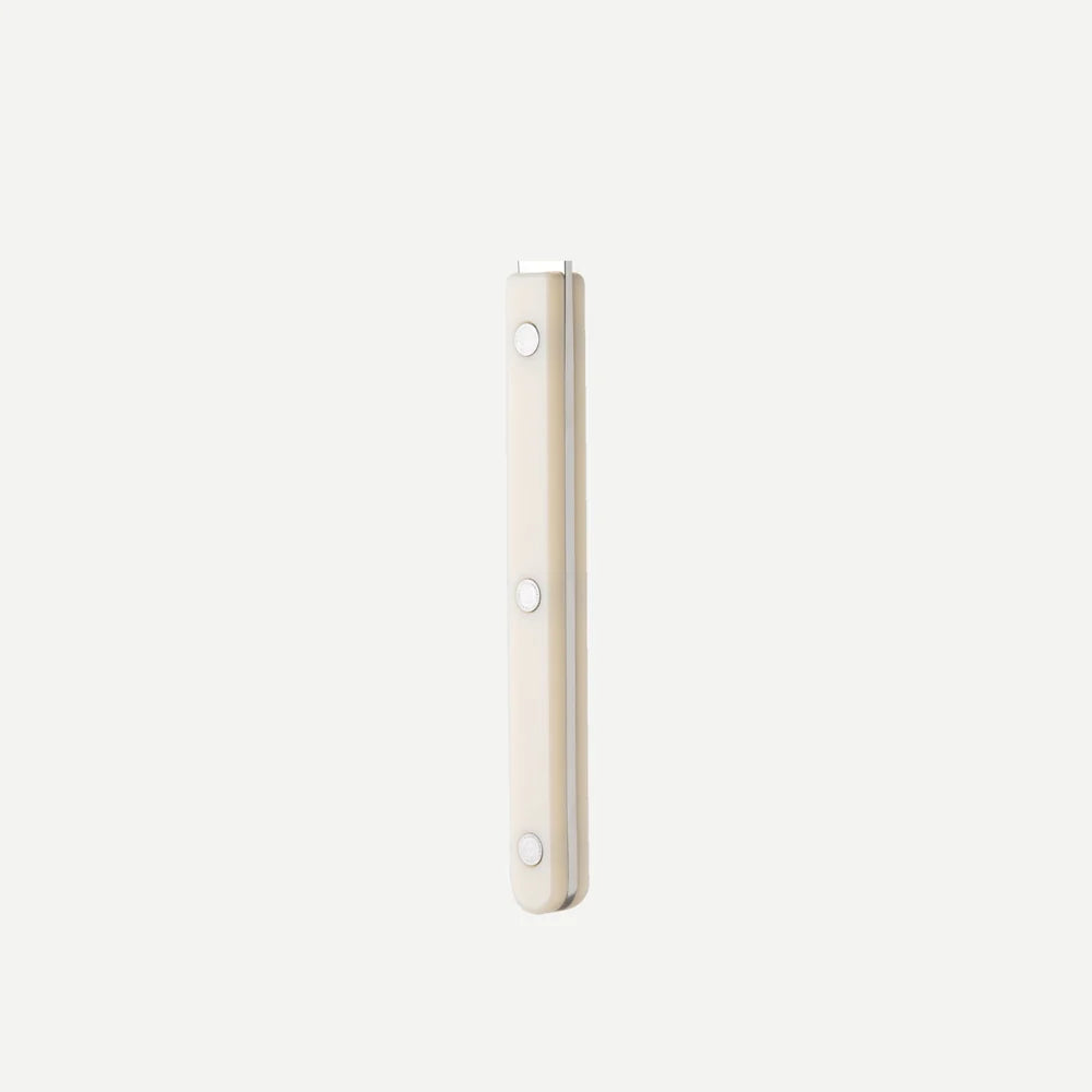 A slim, rectangular handle, finished in a warm cream or off-white color, shown vertically against a solid off-white background.
