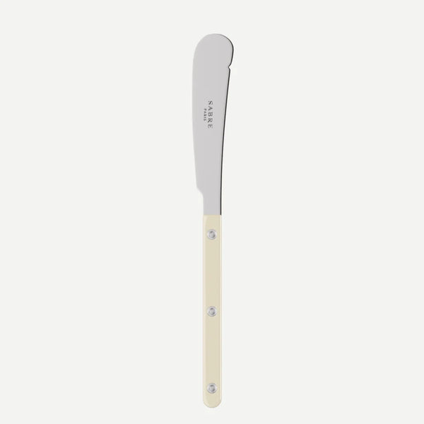 Ivory handle butter knife with "sabre paris" stamped on it on flat white background