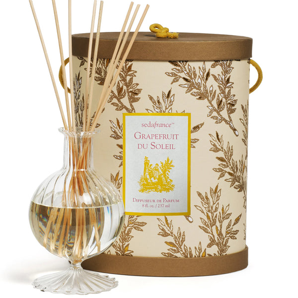 Gold and tan diffuser set with packaging on flat white background 