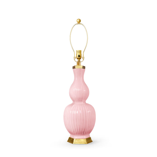 A pink ribbed ceramic table lamp with a gold-finished metal collar, gold wire shade support, and gold hexagonal base on a white background.