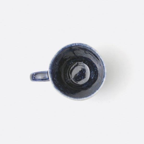 A navy blue stoneware mug with a tie-dye-like pattern and a sea urchin-esque texture, displayed against a white background.
